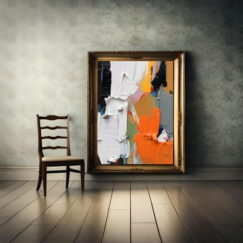Abstract painting in a gold frame on a textured wall with a wooden chair.