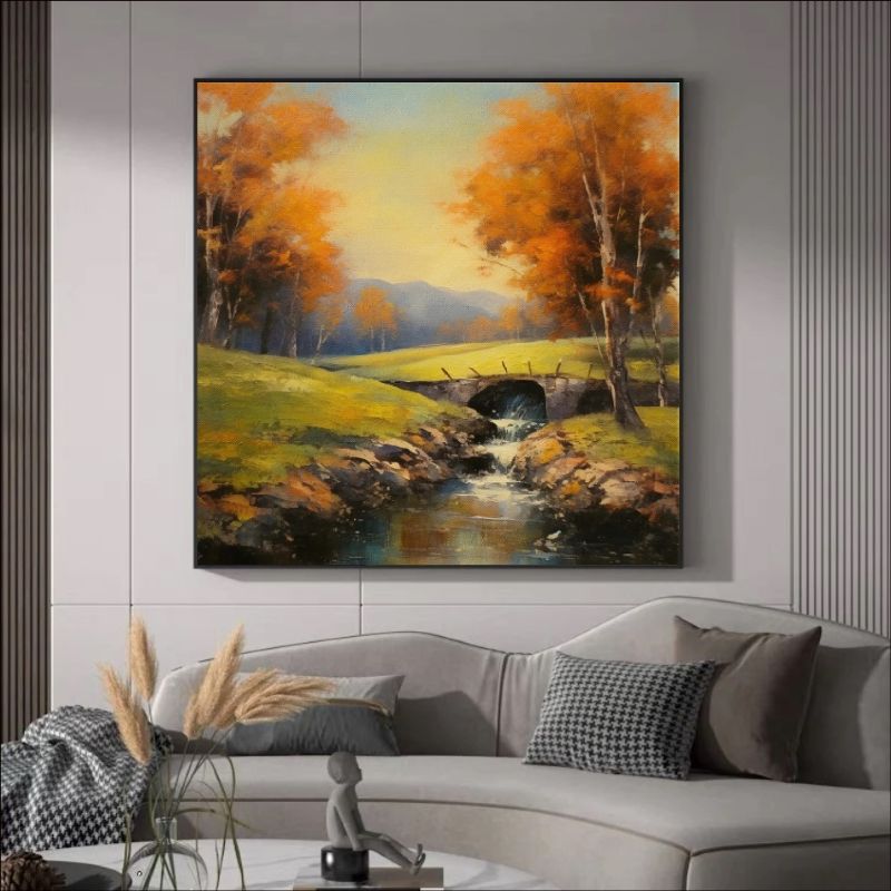 Landscape painting of a bridge over a stream with autumn trees in a living room.
