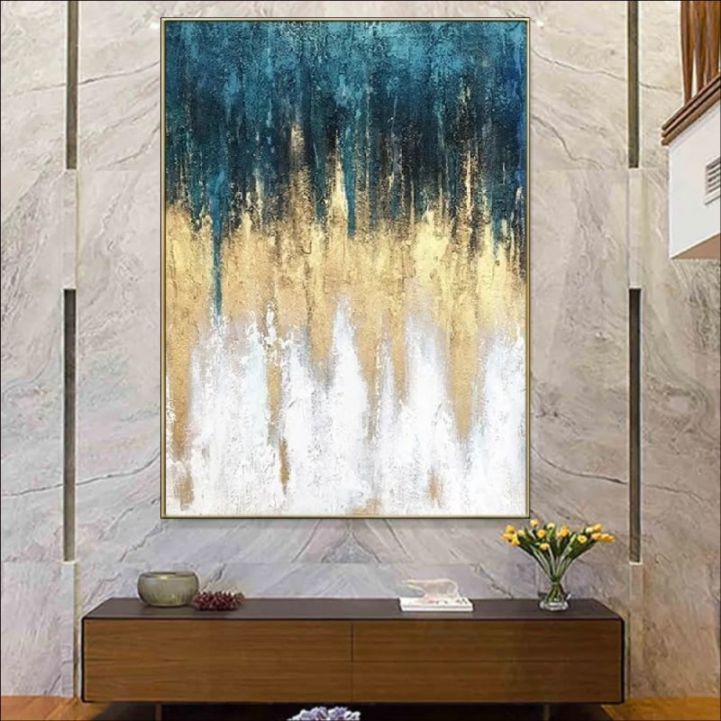 Vertical abstract painting featuring textured rain-like strokes transitioning from deep teal blue to shimmering gold and white, modern luxury wall art style.