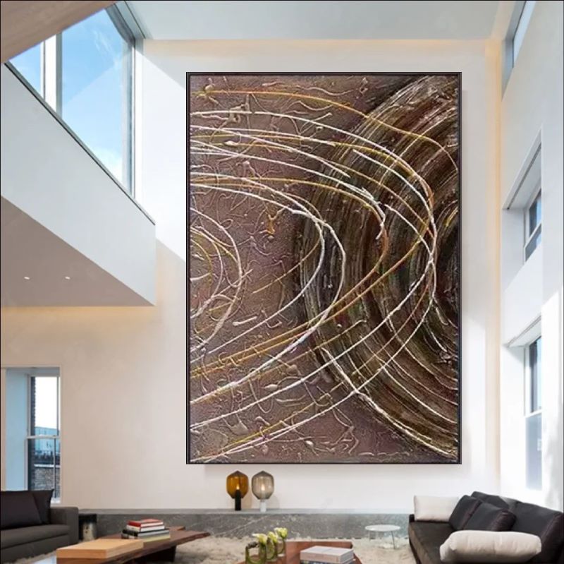 Textured abstract painting featuring deep brown background with dynamic white and gold swirling lines resembling celestial orbits, modern wall art style.