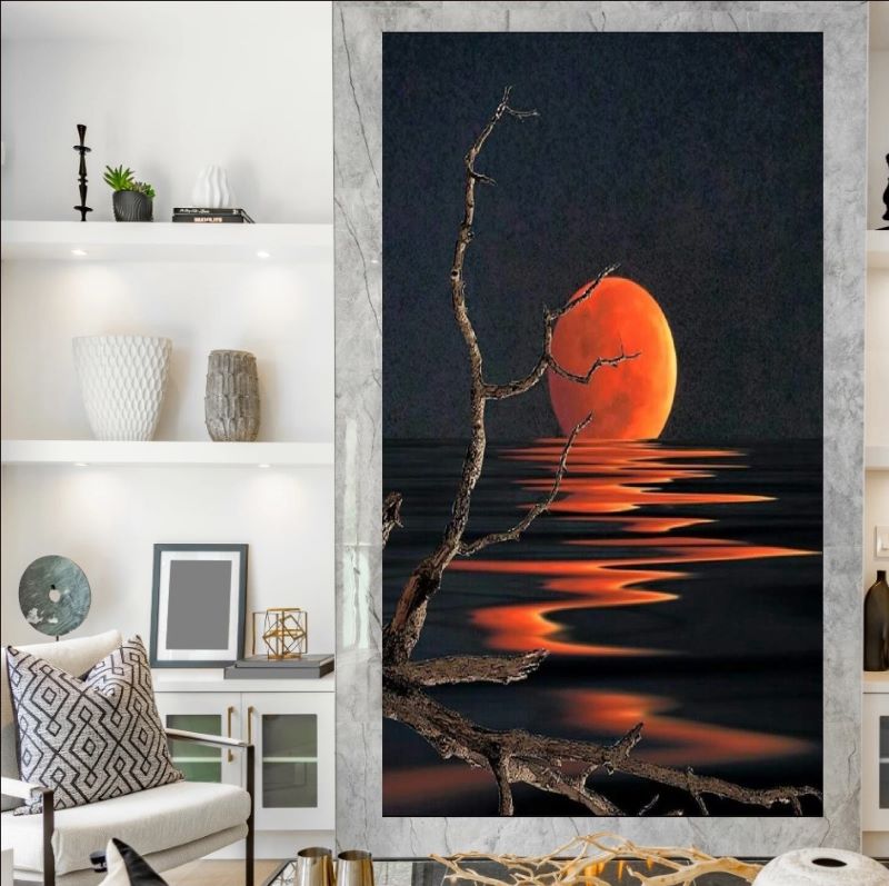 Artistic depiction of a red sun setting over water with bare branches in the foreground.