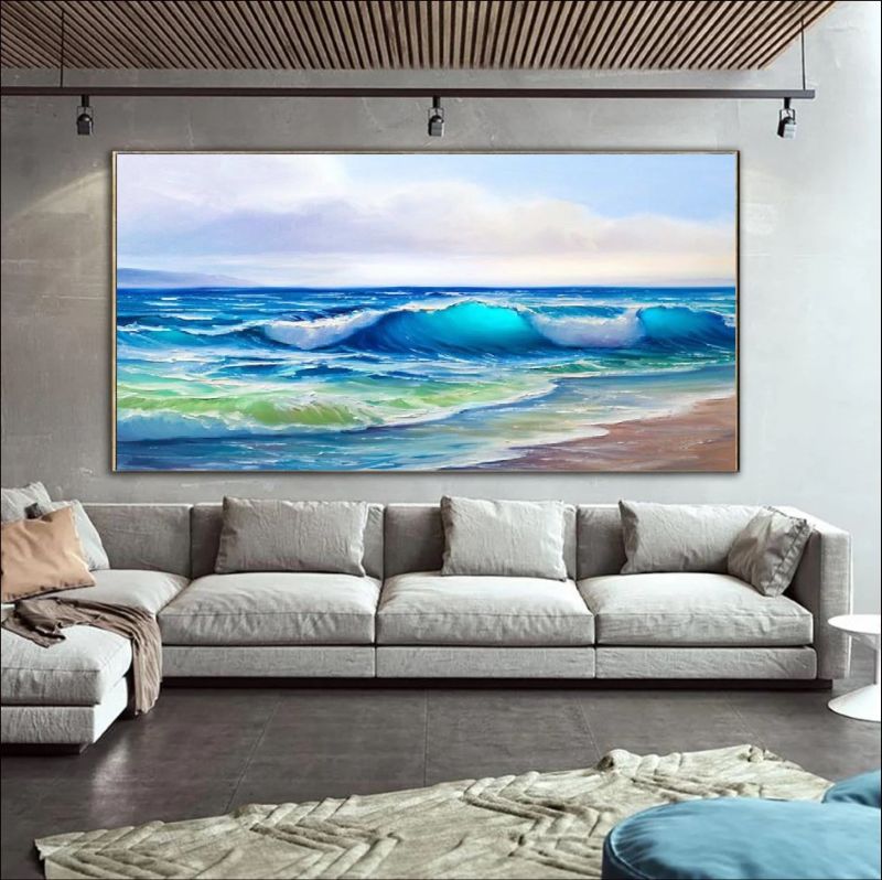 Modern living room with a beige sofa, colorful pillows, and a large framed artwork of a beach scene.