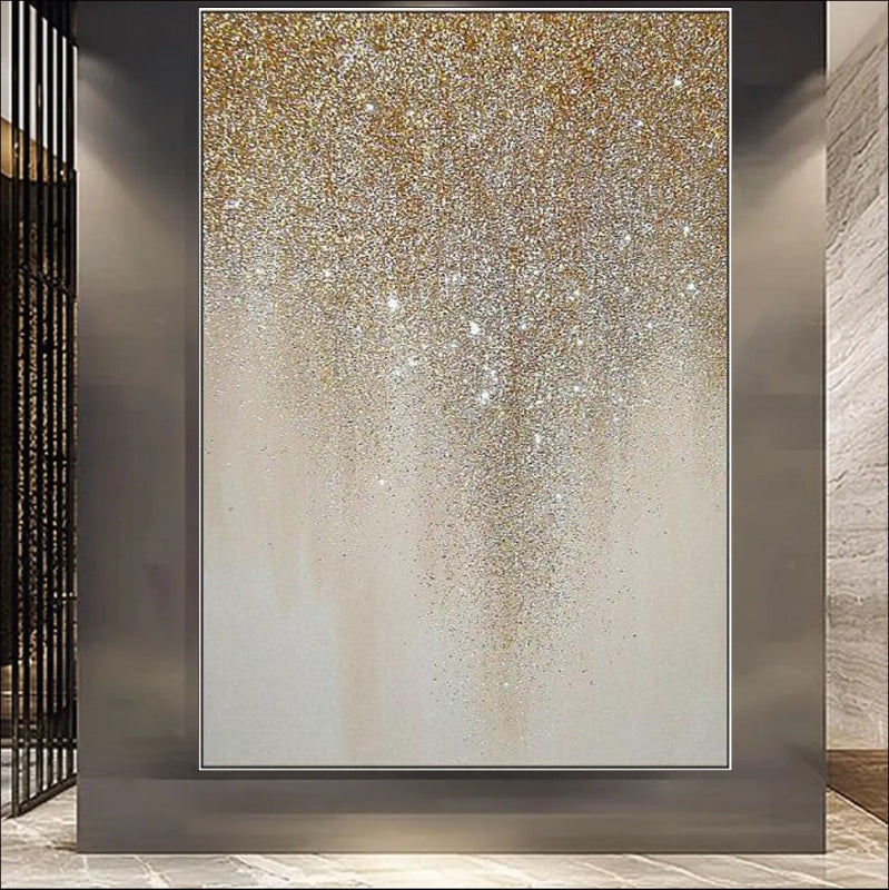 An abstract painting featuring golden glitter cascading in a drip-like pattern on a neutral beige canvas. A luxurious and elegant wall décor piece for modern interiors.