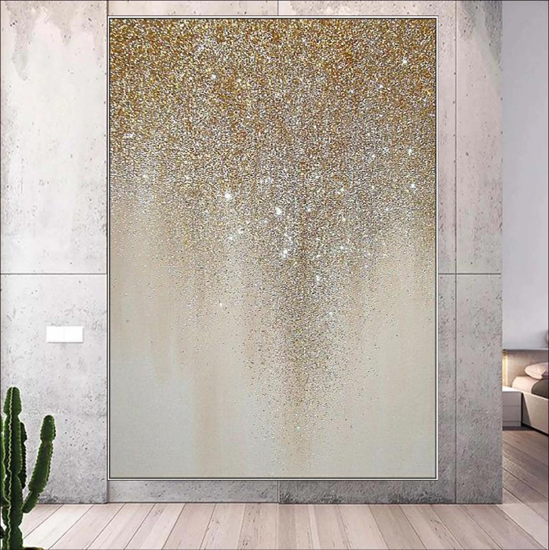 An abstract painting featuring golden glitter cascading in a drip-like pattern on a neutral beige canvas. A luxurious and elegant wall décor piece for modern interiors.