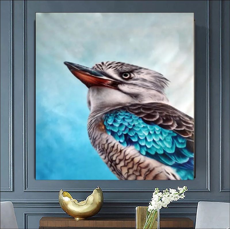 Realistic oil painting portrait of a Kookaburra bird featuring vibrant turquoise blue wing feathers and detailed plumage against a soft blue background.
