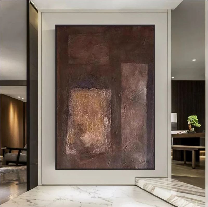 Abstract painting featuring deep brown, rust, and copper block textures hanging above a bed in a modern minimalist room, rustic wall art style.