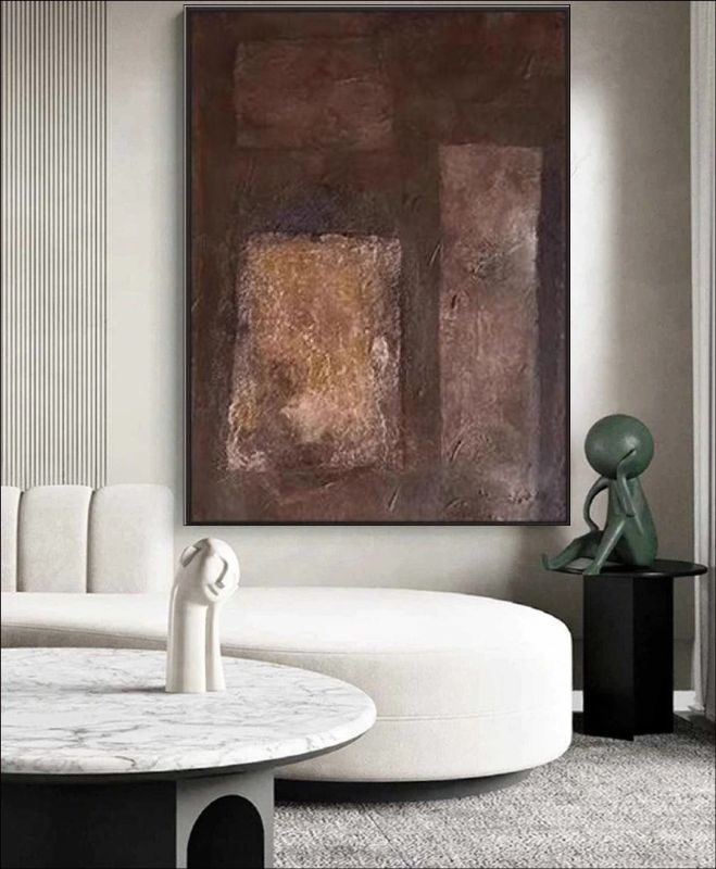 Abstract painting featuring deep brown, rust, and copper block textures hanging above a bed in a modern minimalist room, rustic wall art style.